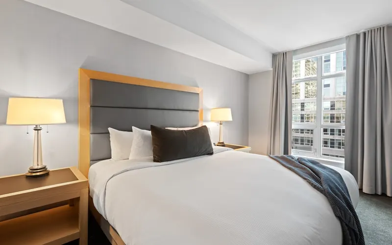 Made bed and window in a bright hotel room