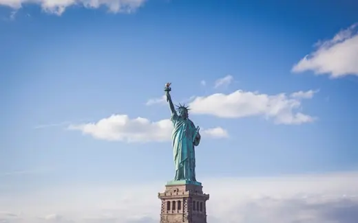 The Statue of Liberty on its pedestal against a blue sky